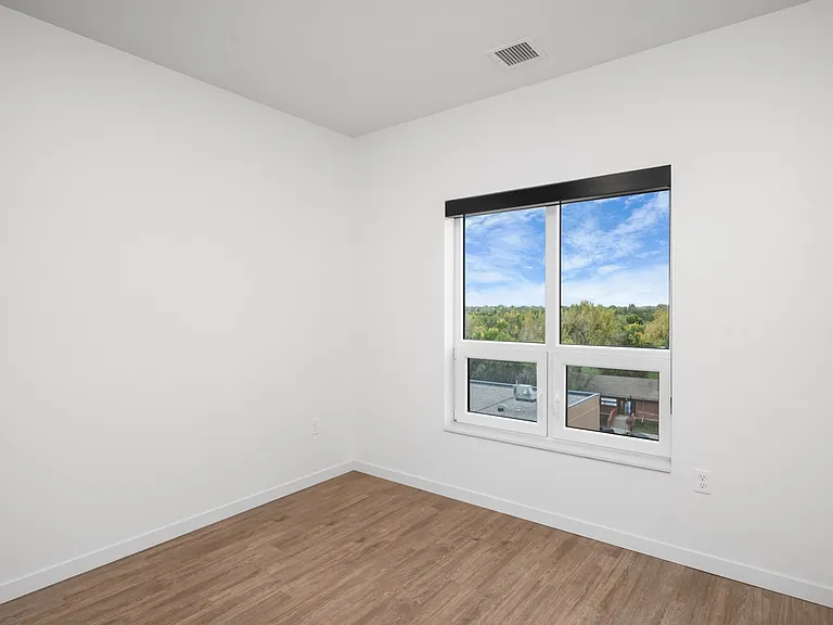 Bright empty room featuring modern hardwood floors and large windows with a scenic view. Bright empty room featuring modern hardwood floors and large windows with a scenic view.