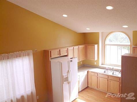 Vaulted kitchen and dining area with huge arch topped window over kitchen sink