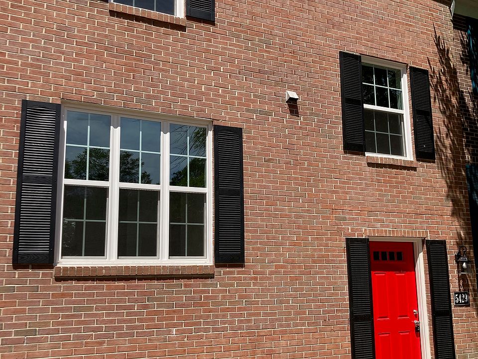 New windows, shutters, landscaping, and freshly painted front door.