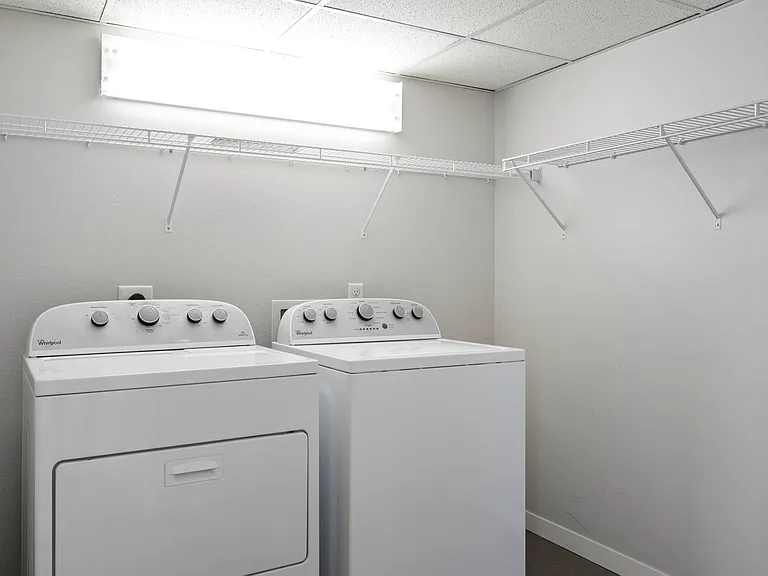 Modern laundry room with efficient washer and dryer set, ample shelving space, and bright lighting. Modern laundry room with efficient washer and dryer set, ample shelving space, and bright lighting.