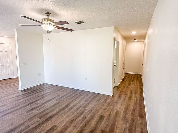 Open concept living room with hallway that leads to 3 bedrooms, 2 bathrooms and the garage.