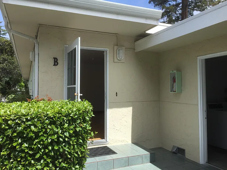laundry room next to the unit, hibiscus bush in front of unit