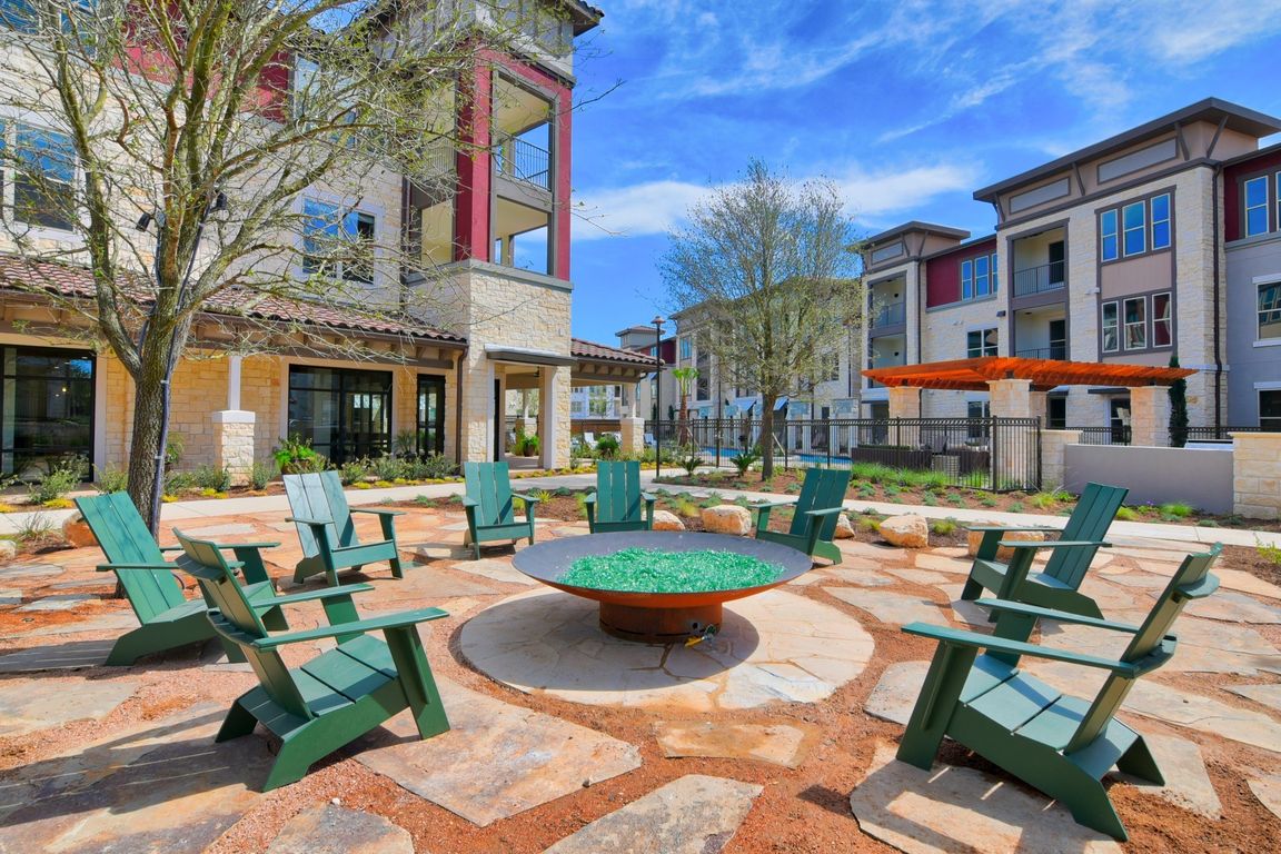 A courtyard with a fire pit and chairs