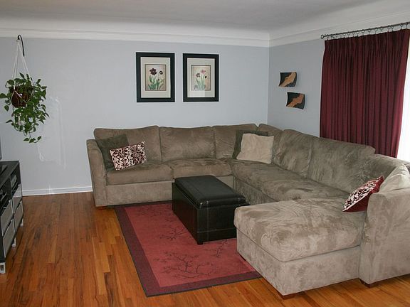 Spacious living room with large front window and refinished hardwood floors