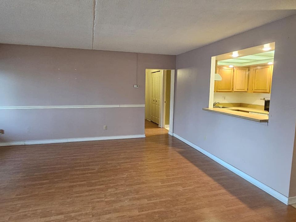 View of living room. Entrance on the right near kitchen. Hallway leads to bedrooms and bathrooms.