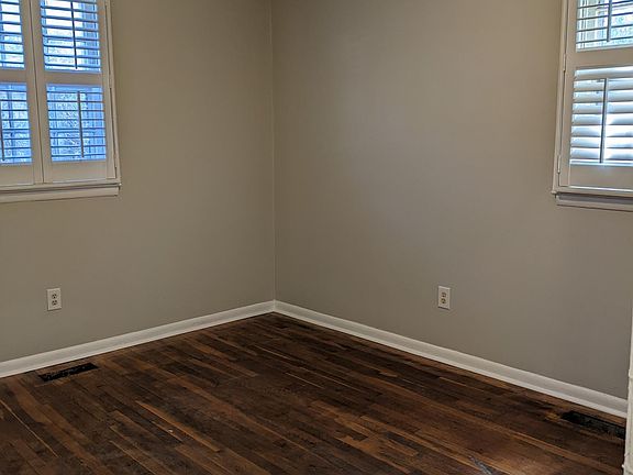 Bedroom #2 with fresh paint, new light, and newly refinished oak hardwood floors!