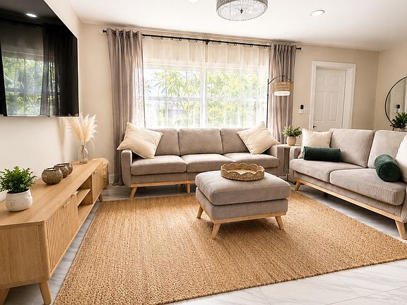 Spacious, fully renovated Naples living room with comfortable seating, smart TV, modern finishes, and plenty of space for families, groups, business travelers, and seasonal stays.