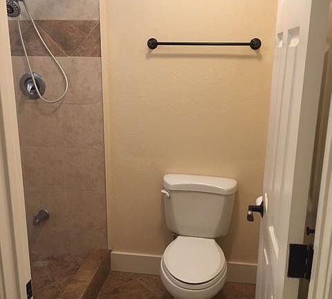 Larger tiled shower, door separating from vanity area.
