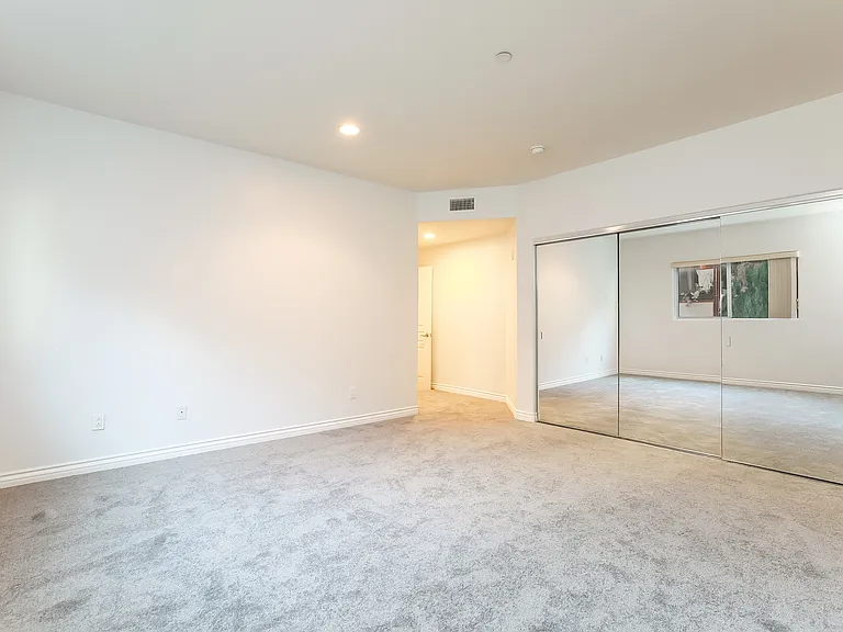 Primary bedroom with wall of mirrored closets