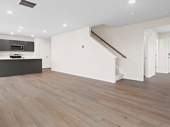 Open 1st floor living room and kitchen in a DRB Homes Glenshaw plan at The Village of College Park.