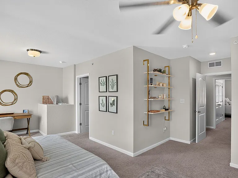 Charming bedroom with elegant decor, featuring a cozy bed, stylish artwork, and a sleek desk for a serene living space.