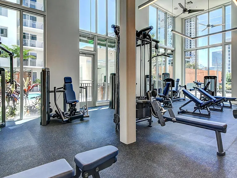 Fitness Studio With Cable Machines and Benches Surrounded by Window Walls