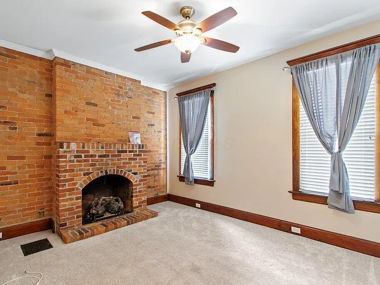 Living room with gas fireplace and ceiling fan
