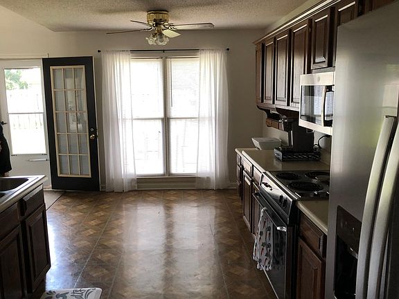 Dark oak cabinets with appliances. Small desk area. Breakfast area . Refrigerator not provided.