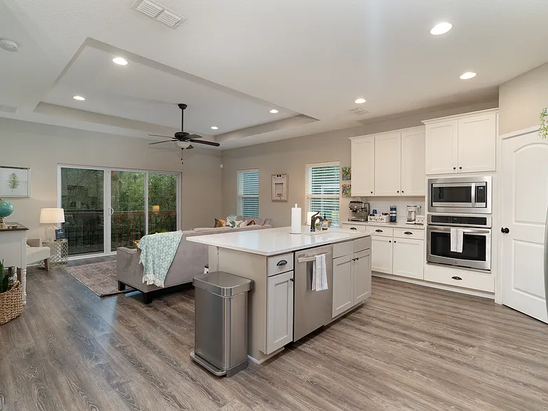 A beautifully functional kitchen workspace complete with a stainless steel dishwasher, large wall oven, integrated microwave, and convenient island prep area
