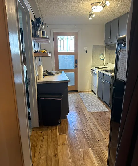 View of the kitchen from the living room/dining room. North facing door into the backyard.