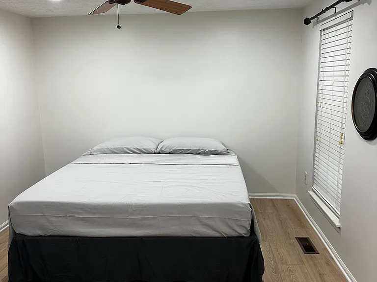 Comfortable bedroom with a ceiling fan, recessed lighting, and a window with blinds for adjustable privacy and light.