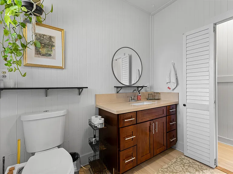 Large bathroom with high ceilings, ceiling fan, window, vanity with storage, bidet, bathtub and shower.