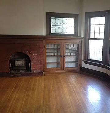 Living room with built in bookcases, non-wood burning fireplace and leaded glass windows, Parkay inlay in oak floors