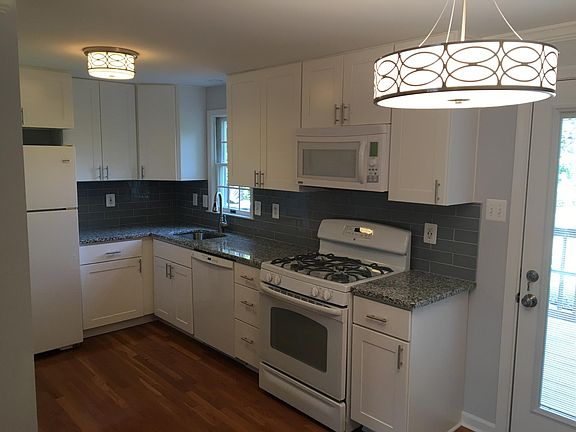 Renovated kitchen with gas range, granite countertops, and USB-equipped outlet.