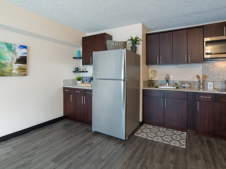 Waikiki Walina Apartments kitchen area with appliances, cabinets, and counters