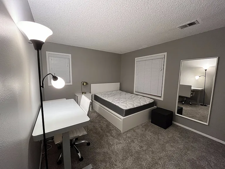 The second bedroom includes a double-size bed, nightstand, desk, mirror, and large closet.