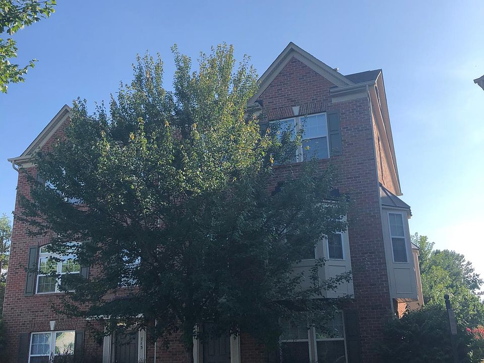 Front exterior, end unit with bay windows.
