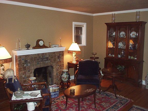Living room with original art tile fireplace and wood floors