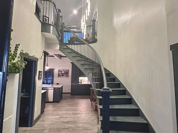 Welcome home! The stunning circular stairwell is a show stopper, and boasts a two story champagne-bubble light fixture.