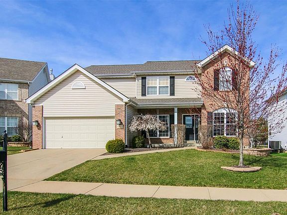 Brick Veneer Exterior with Coach Lights on the Garage and Leaded Glass front door....