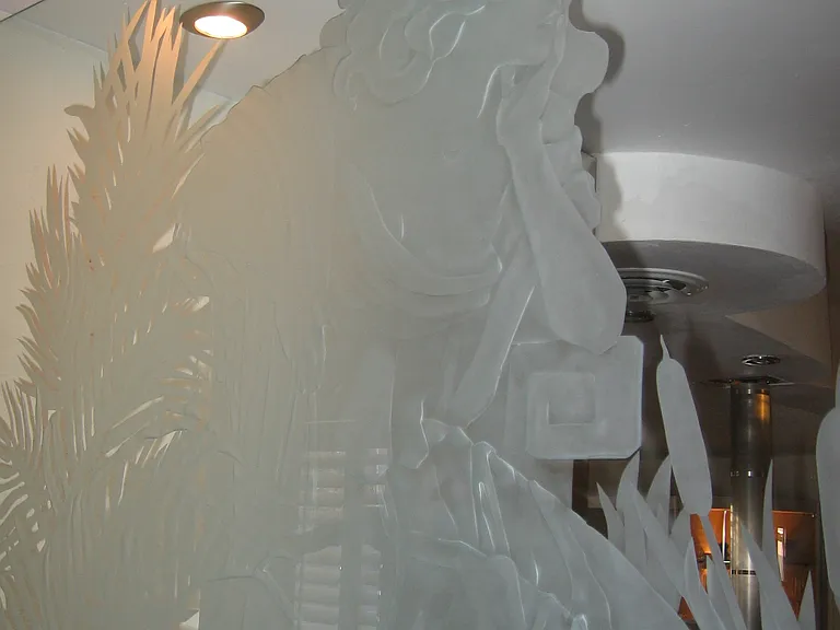 Glass carvng, multi-level of "Flora" looking over people in dinning room,
signed