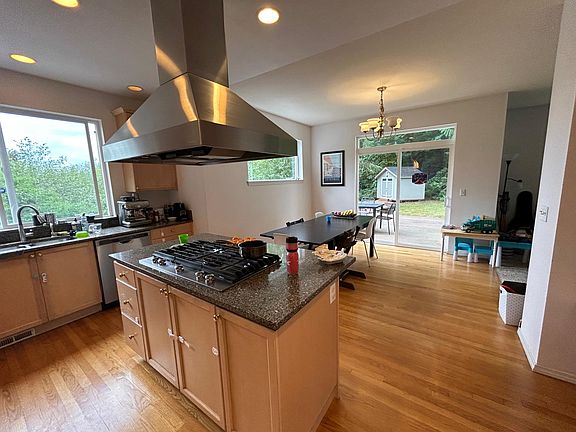 The kitchen features new granite countertops, stainless steel appliances, gas cooktop on a center island.