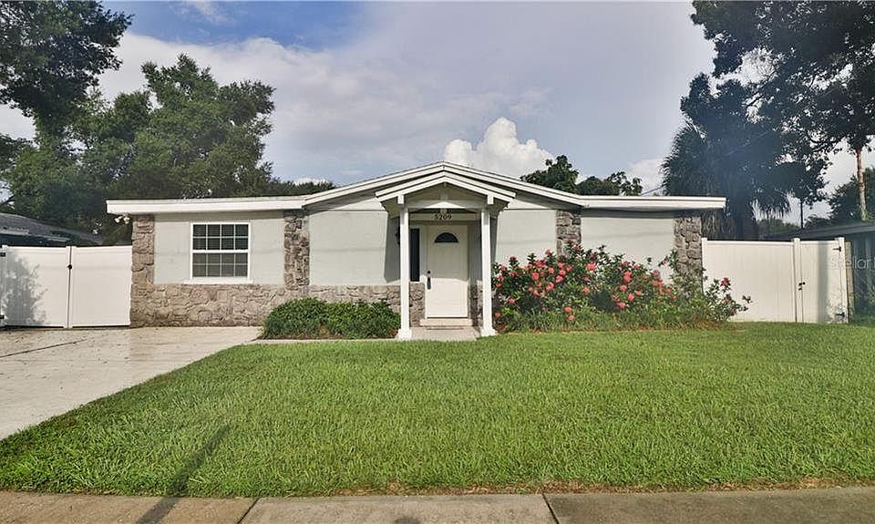 Front of house with large driveway for offstreet parking and side port for additional car or boat