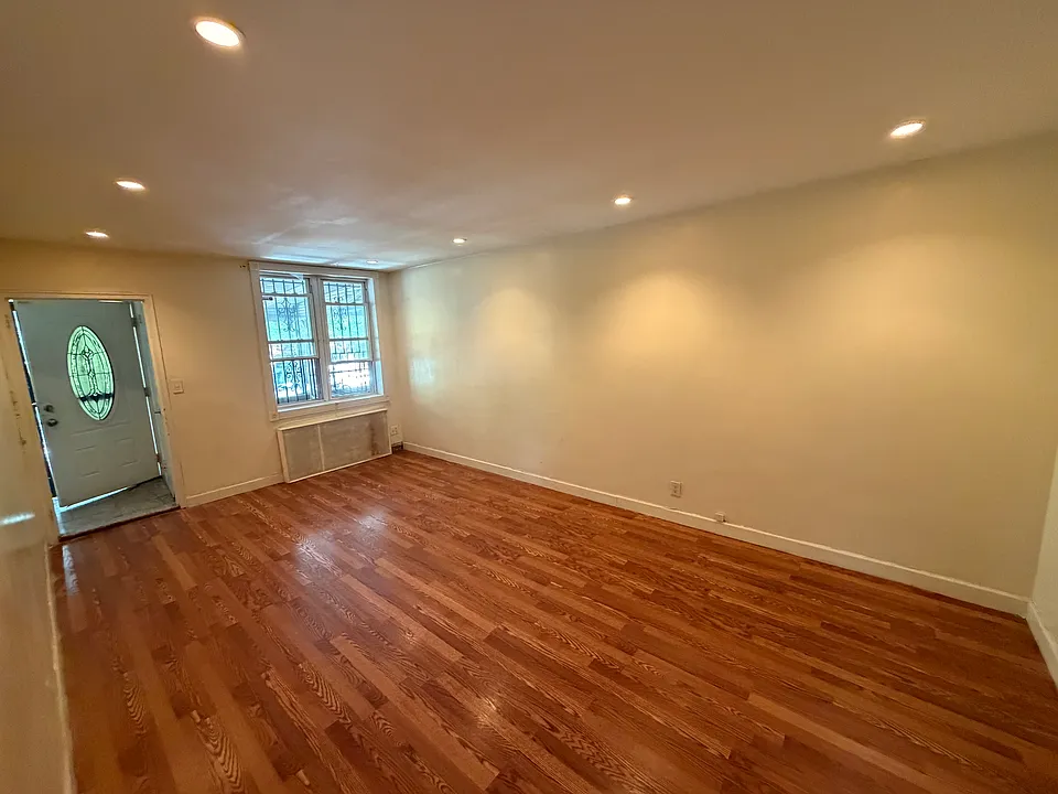 Spacious living room with beautiful floors, recessed lighting, and abundant natural light.