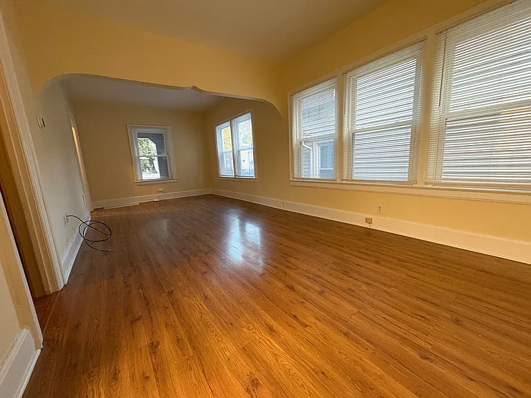 Another view of the living room, as viewed from the kitchen. To the left is the storage area. All windows have brand new blinds, installed in 2025.