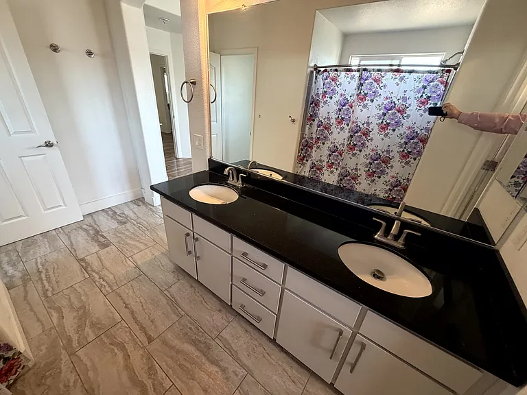 Private ensuite bathroom. Dual-sink vanity with granite countertop.