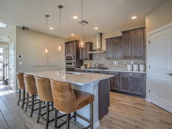 The kitchen island with pendant lighting allows for eating casual breakfasts in style.