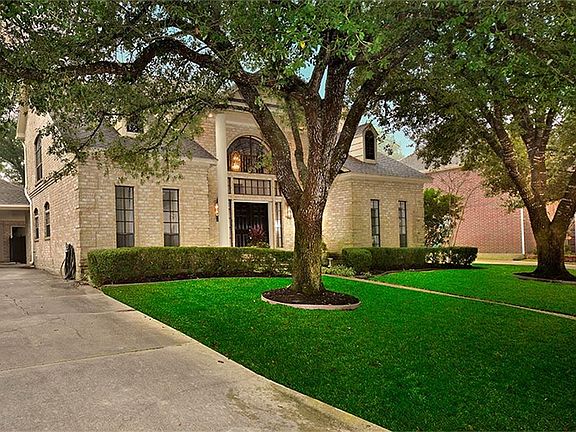 View of the home with 2 car garage and carport.
