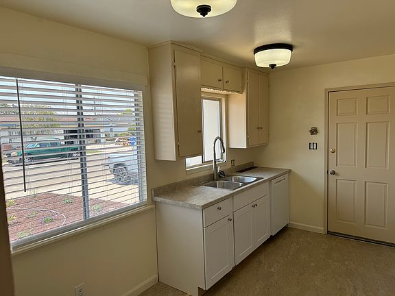 Modern sink and and dishwasher (retro lights) with sunny dining area 
adjacent to the kitchen.
