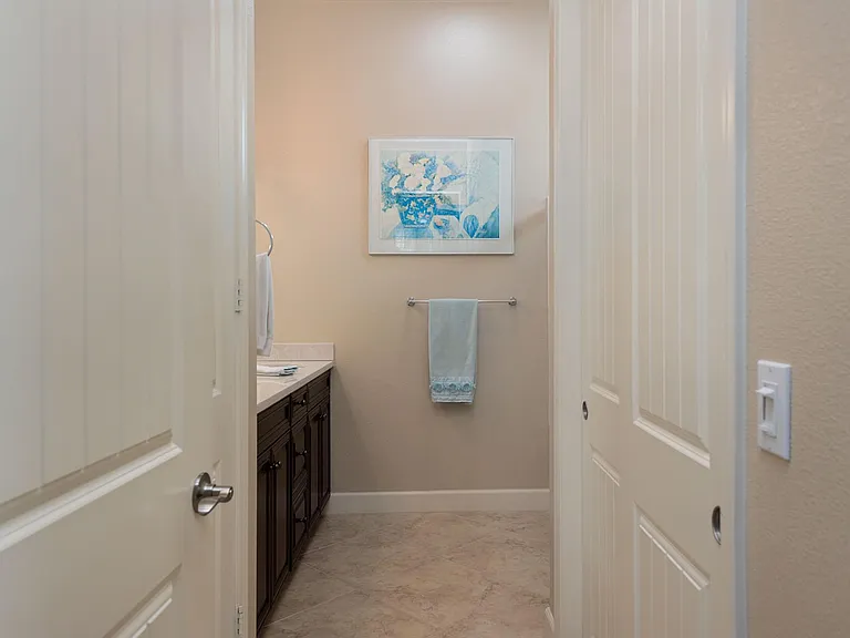 En suite guest bathroom with shower over tub, double vanities, separate water & wardrobe closets.