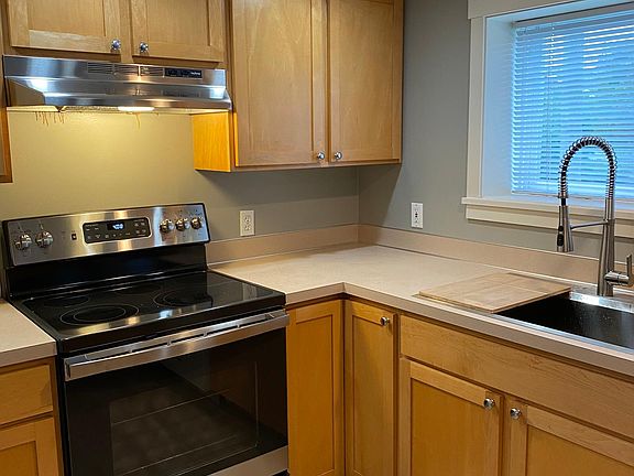 Kitchen with new range, hood, and full size sink with a great prep cutting board