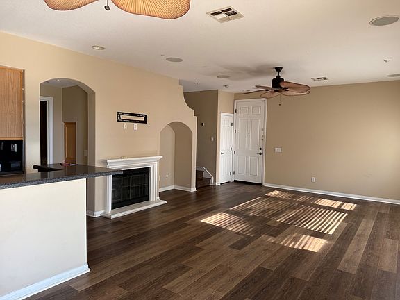 View from patio door showing main entrance, decorative fireplace and living room area