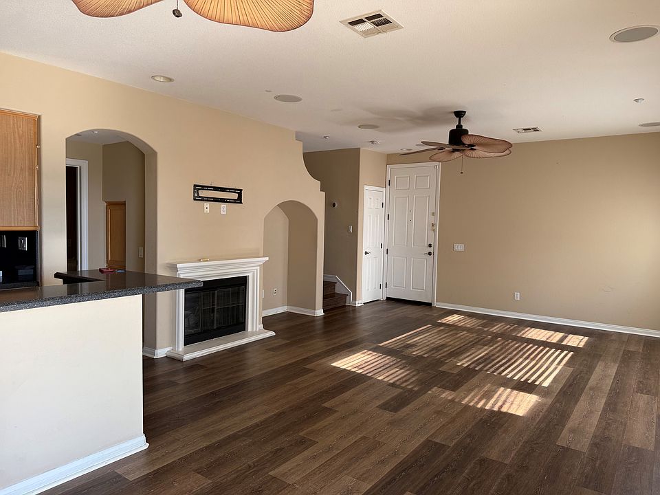 View from patio door showing main entrance, decorative fireplace and living room area
