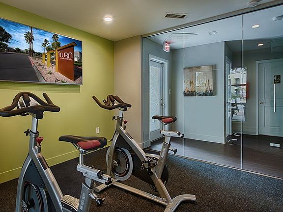 Cycling equipment with large television monitor and glass wall.