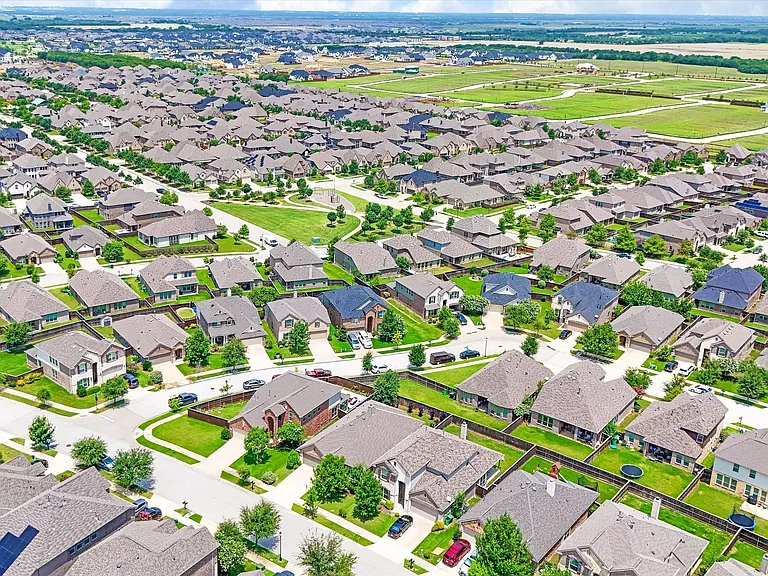 Aerial perspective showcasing a residential community with numerous single-family homes, each featuring individual landscaping