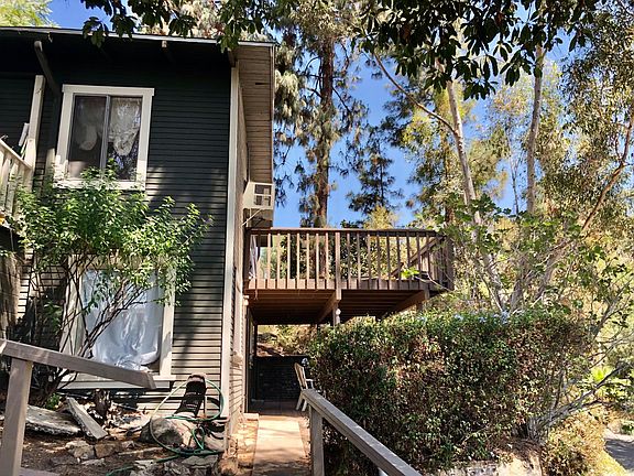 Trees view with patio and deck. The deck opens onto the large dedicated lot, then to the garages and parking at the street.