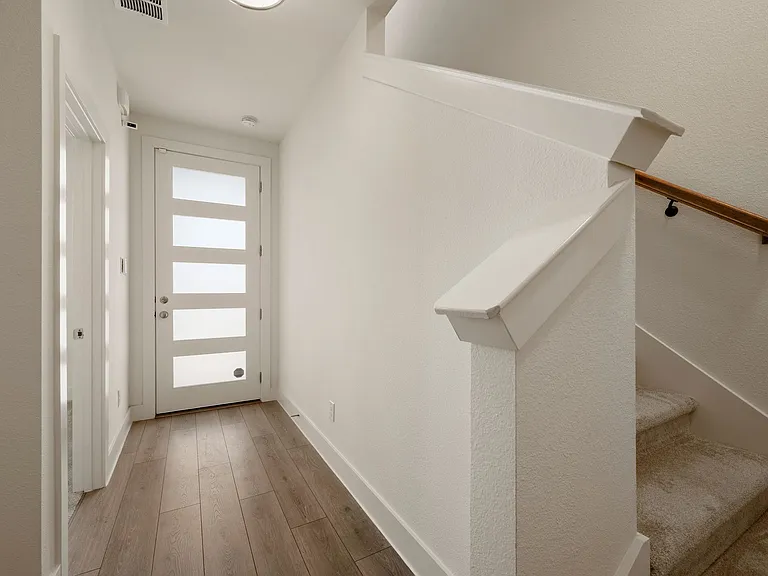 Froot door view with stairs to the second floor on the right and Bedroom #1 on the left.