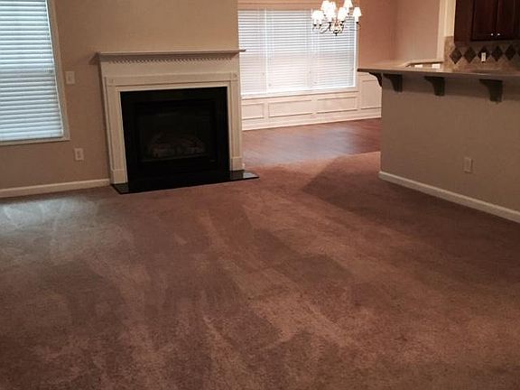Open spacious family room with gas burning fireplace and view into dining room and kitchen