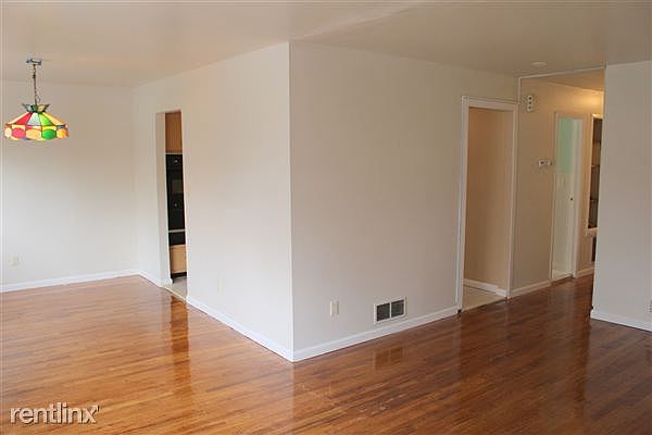 View of living room/dining room and kitchen entrances from a