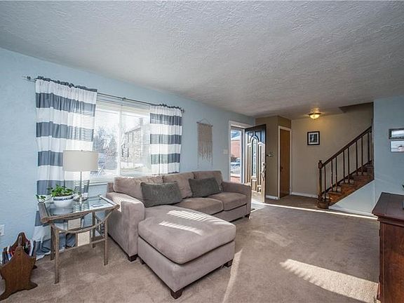 Spacious living room with large window overlooking front lawn that fills the room with natural light.